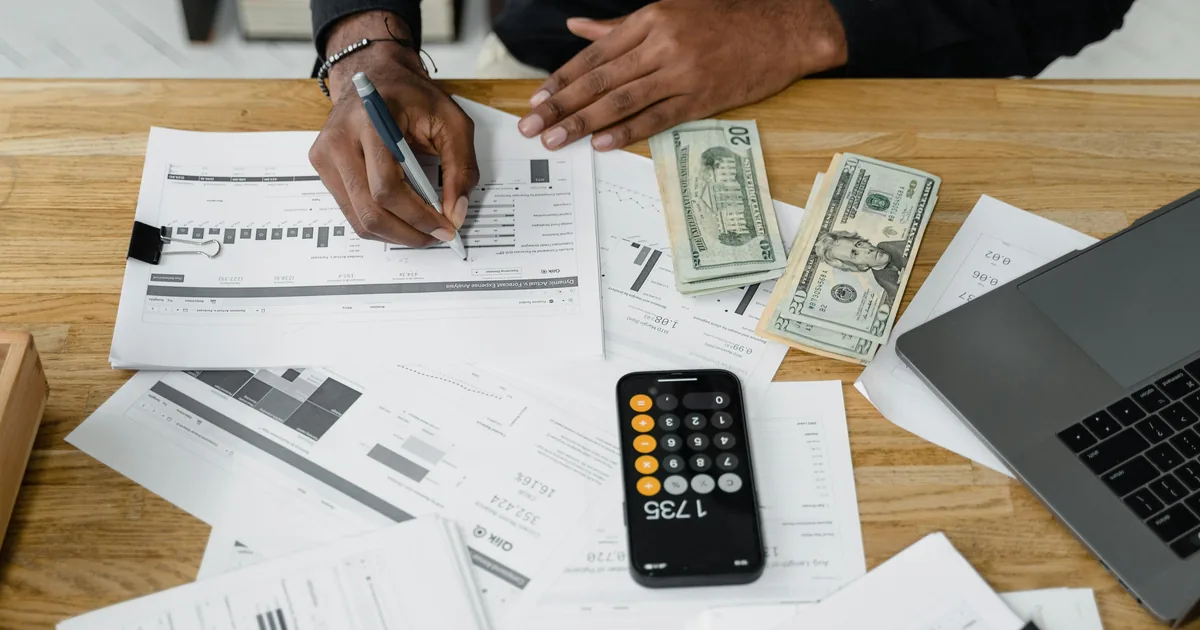 Accountant working at desk with laptop, calculator, and financial documents — connecting Shopify to QuickBooks Online for accurate bookkeeping
