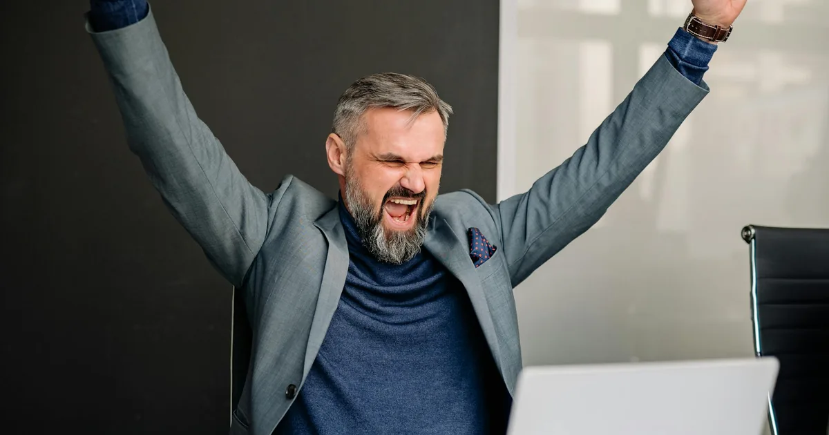 Business professional celebrating success at a laptop — WeIntegrate launches Invoice, Payment, and Credit Memo support for Shopify merchants in QuickBooks Online