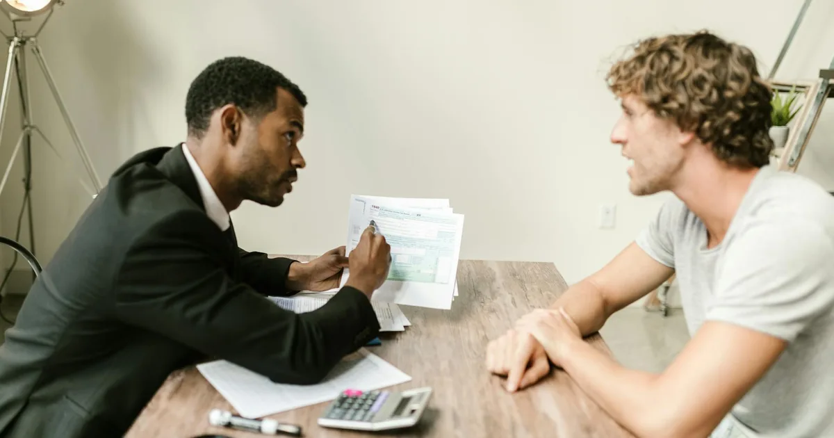 Financial advisor reviewing documents with a client at a desk — per-transaction Shopify QuickBooks Online integration for accountants and agencies